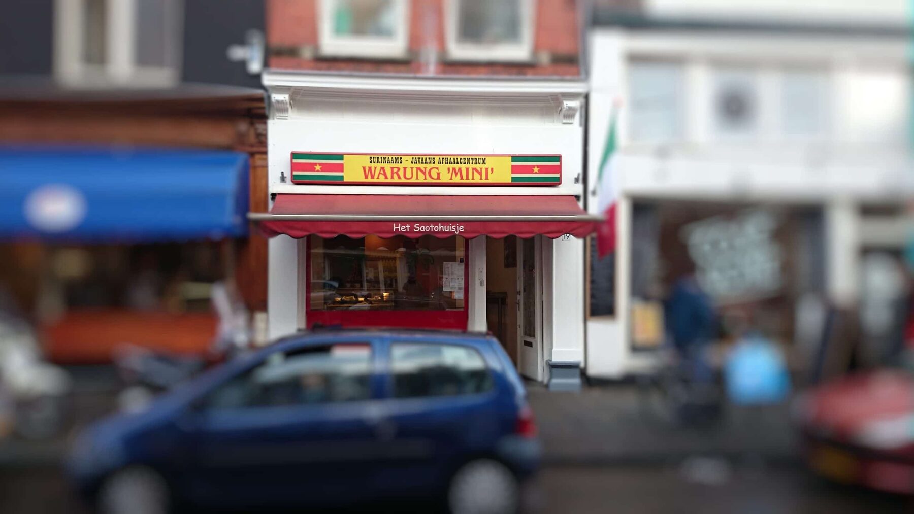 De gevel van Warung Mini aan de Van Woustraat met de luifel 'Het Saotohuisje'